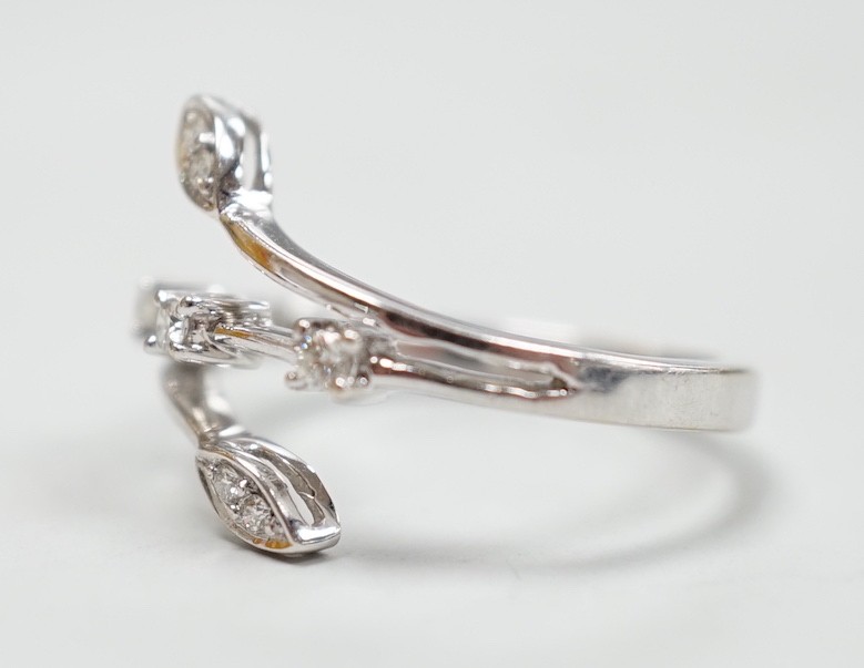 A modern 18k white metal and seven stone diamond chip set petal ring, size L, gross weight 3.3 grams.